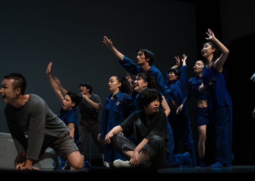 舞台で上を見上げ、熱演するパフォーマーたち