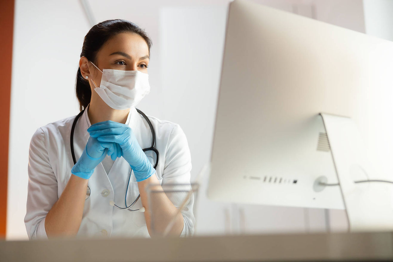 masked-healthcare-professional-watching-computer.jpeg