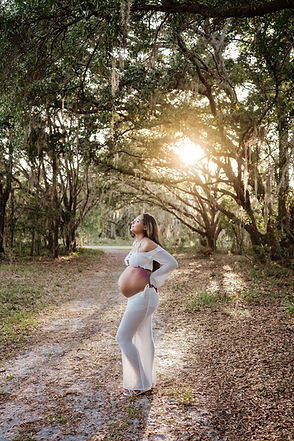 Golden hour maternity session with sun shining in the trees- Central Florida