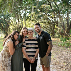 Three generation of family embracing together outdoors during a central Florida family photography session 
