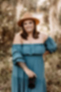 Woman in a teal off the shoulder dress smiling outdoors for a photography headshot session in Central Florida.