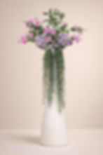 Composizione floreale decorativa con vaso bianco alto