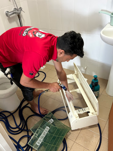 employee cleaning aircon frame