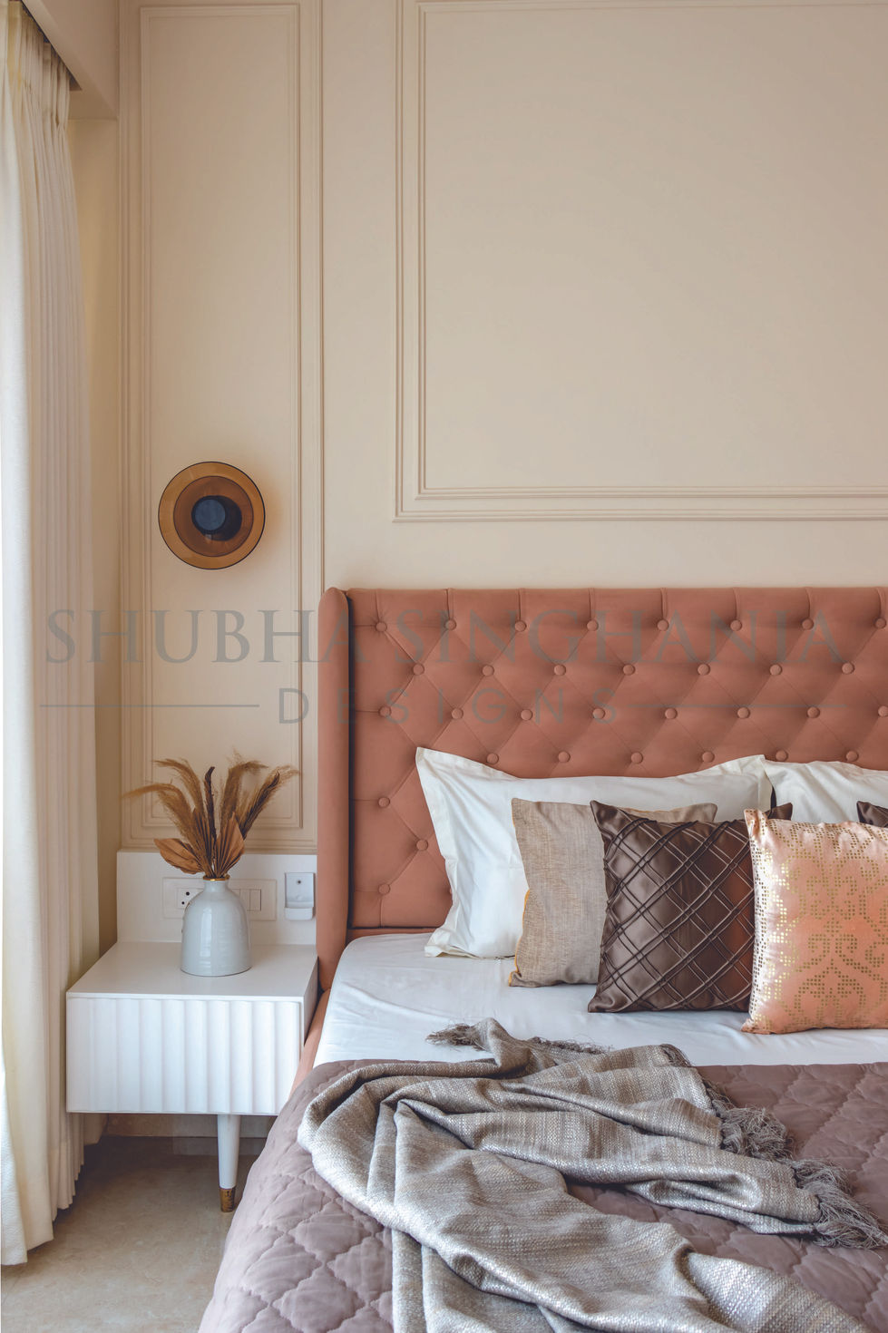 Elegant bedroom with tufted headboard and decorative pillows.