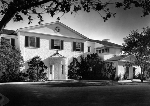 Exterior view of the home of David O. Selznick at 1050 Summit Drive, in Beverly Hills. Home was built in 1933, 1934 as a Colonial Revival style white brick mansion. The architect was Roland E. Coate; landscape architects, Florence Yoch and Lucille Council.