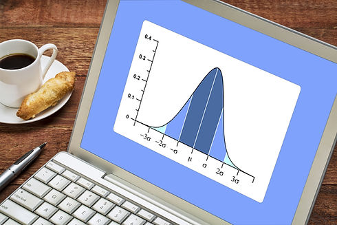 Gaussian, bell or normal distribution curve on laptop computer with a cup of coffee.jpg