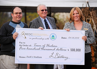 Laurel Adams presenting a check to The Town of Hudson for Zach's Field Statium, a Brownfields project.