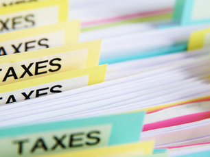 Rows of colorful file folders labeled "TAXES" are neatly organized, creating a structured and organized office environment.