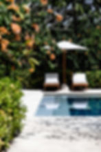 Peaceful poolside relaxation with sunbeds and umbrella at Revivo Wellness Resort Bali