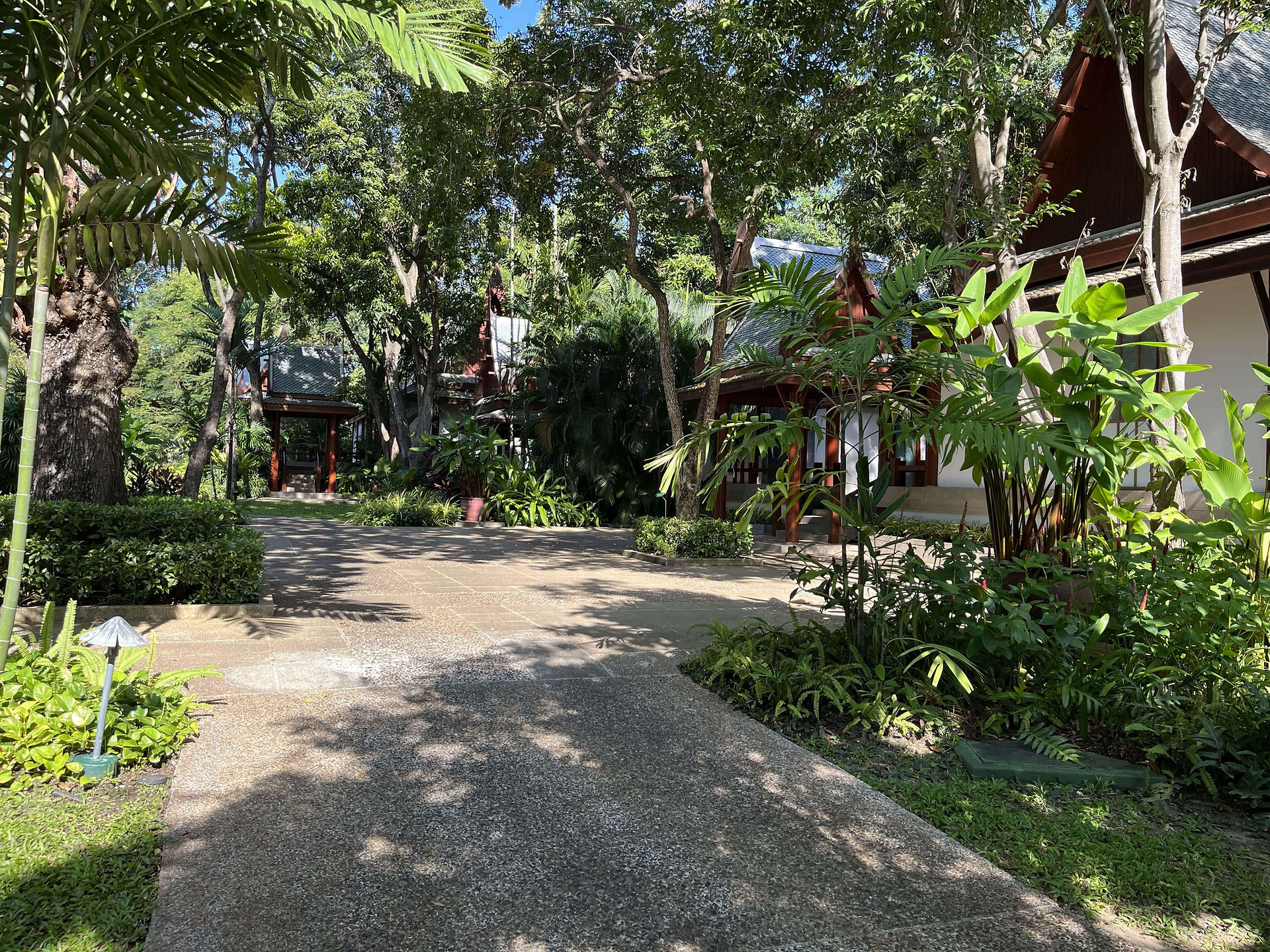 Peaceful garden pathway surrounded by tropical greenery at Chiva-Som in Hua Hin, Thailand.