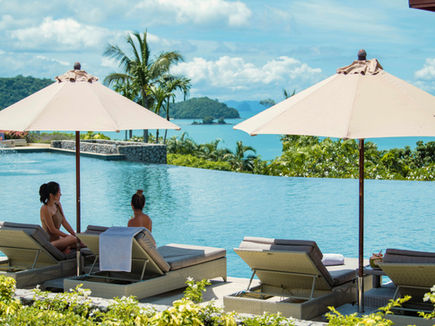 Guests relaxing by the infinity pool at Amatara Wellness Resort Phuket