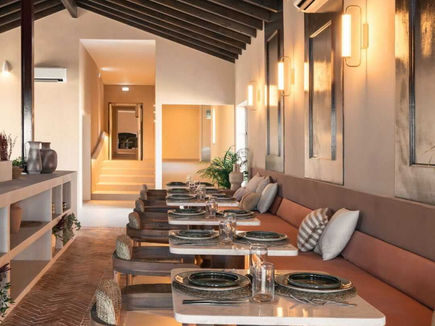 Restaurant at Shanti-Som Algarve, with banquette seating beneath a vaulted beamed ceiling