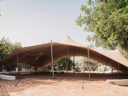 Open-sided yoga tent at Shanti-Som Algarve, set on a brick terrace beneath olive trees