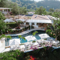 The Retreat Costa Rica from the hillside, with its main pool, terraces and surrounding rainforest