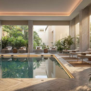Indoor pool at ZEM Wellness Clinic Altea, lined with loungers and planted greenery beneath soft lighting