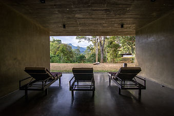 Covered relaxation area at Santani Wellness Resort with loungers facing the mountains