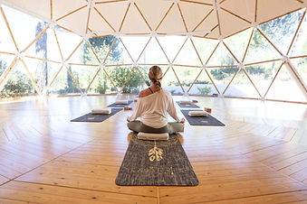 Woman meditating inside yoga dome at MasQi Energy House wellness retreat