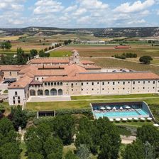 Castilla Termal Monasterio de Valbuena in Spain, a restored historic monastery surrounded by vineyards, featuring an outdoor pool and countryside views