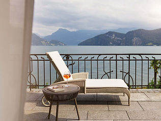 Lake and mountain views from balcony with sunbed and drink at Chenot Palace Weggis