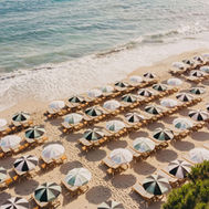 Lily of the Valley Hotel beach club with parasols and sunbeds by the sea