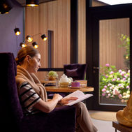 Woman reading a book in the tea lounge at Ayurveda Resort Mandira Austria