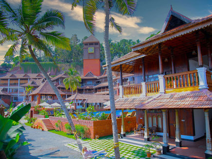 Palm tree garden view of Ayursoma Ayurveda resort with clock tower in Kerala