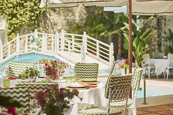 Outdoor dining terrace beside a garden bridge at Marbella Club.
