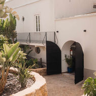 Whitewashed farmhouse courtyard at Shanti-Som Algarve, with arched doorways and dry-stone terracing