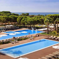 Outdoor swimming pools surrounded by pine trees at Epic Sana Algarve in Portugal