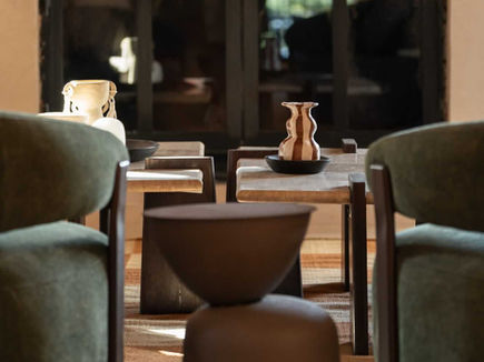 Quiet seating corner at Shanti-Som Algarve, with armchairs beside arched glass doors