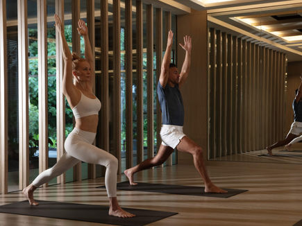 Two guests in a yoga session in the timber-screened studio at Layan Life by Anantara