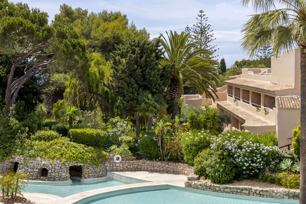 Lush gardens and cascading pools surrounded by greenery at Vilalara Grand Hotel Algarve.
