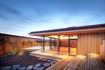 Modern wooden outdoor spa pavilion at Ayurveda Resort Mandira in the evening.