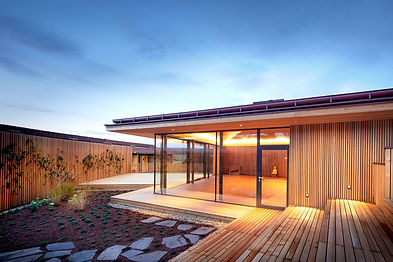 Modern wooden outdoor spa pavilion at Ayurveda Resort Mandira in the evening.