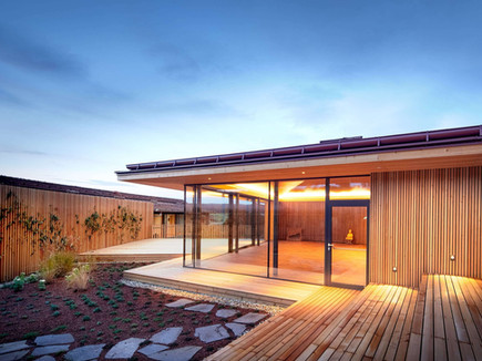 Modern wooden wellness pavilion at Ayurveda Resort Mandira at sunset