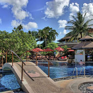 Outdoor pool area with sun loungers at Mangosteen Ayurveda & Wellness Resort Phuket
