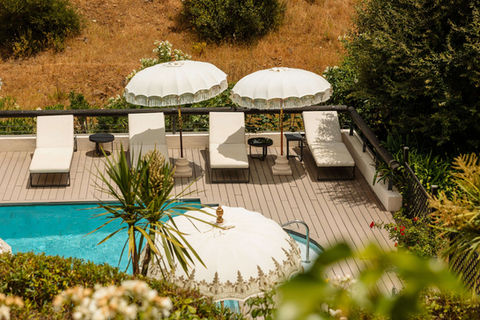 Poolside deck with white loungers and parasols at Shanti Som