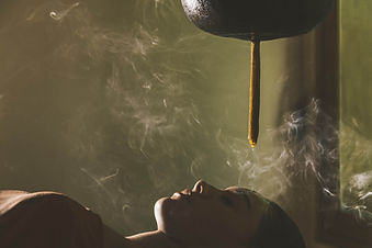 Ayurvedic Shirodhara therapy with warm oil poured onto the forehead at Six Senses Vana.