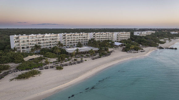 Aerial view of Palmaïa luxury wellness resort on a private white-sand beach in Riviera Maya.