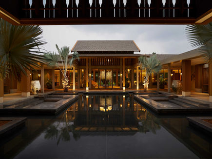 RAKxa CHA tea lounge lit at dusk, reflected in the surrounding water