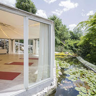Light-filled yoga pavilion beside a lily pond at Preidlhof in Italy
