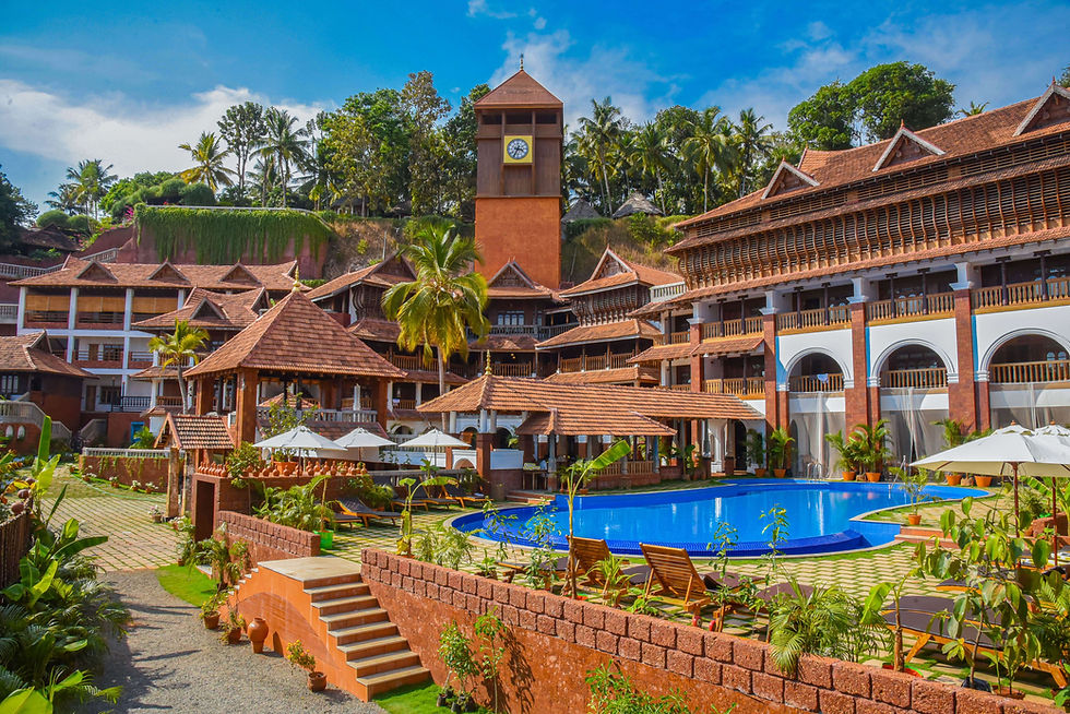 Ayursoma Kerala Ayurveda retreat with swimming pool, heritage clock tower, and palace-style architecture surrounded by tropical greenery.