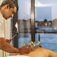 Therapist performing traditional fire cupping therapy at Zulal Wellness Resort