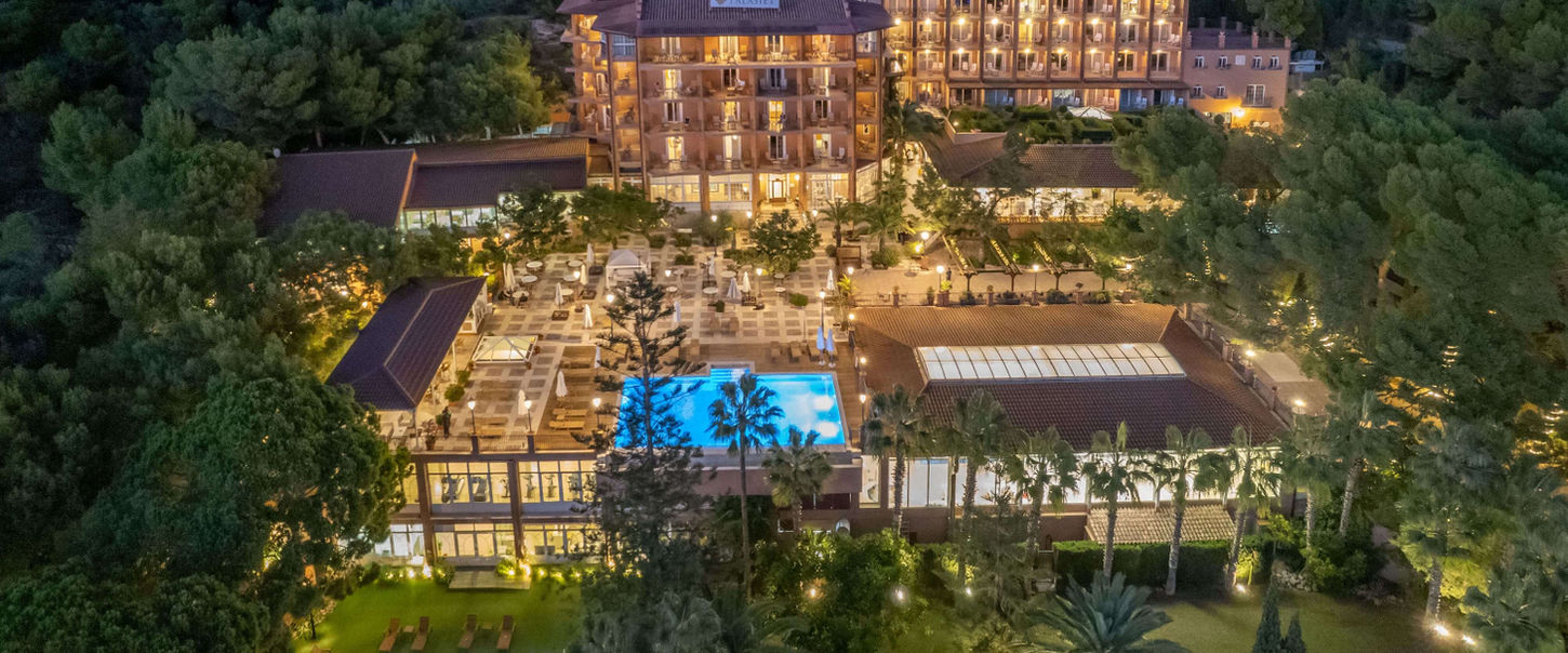 Palasiet Thalasso Clinic illuminated at night, nestled in the Spanish hillside.