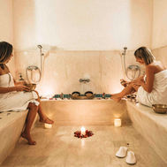 Two guests in the hammam at Paradis Plage, seated on warm stone benches