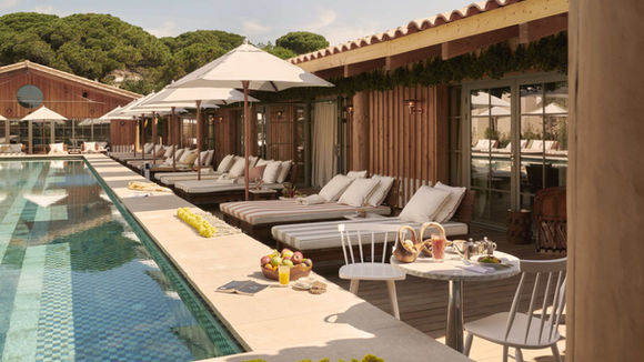 Shape Club swimming pool at Lily of the Valley Hotel with loungers and umbrellas