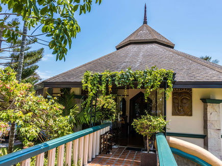 Entrance to the Ayurveda spa building surrounded by lush greenery at Mangosteen Resort