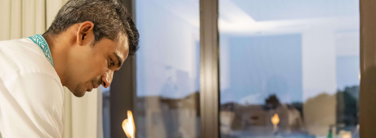 Therapist performing traditional fire cupping therapy at Zulal Wellness Resort