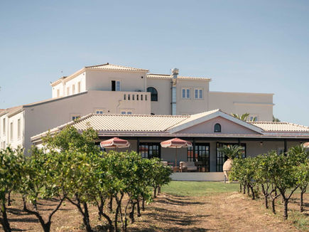 Restored 19th-century farmhouse at Shanti-Som Algarve, seen across the orange orchard