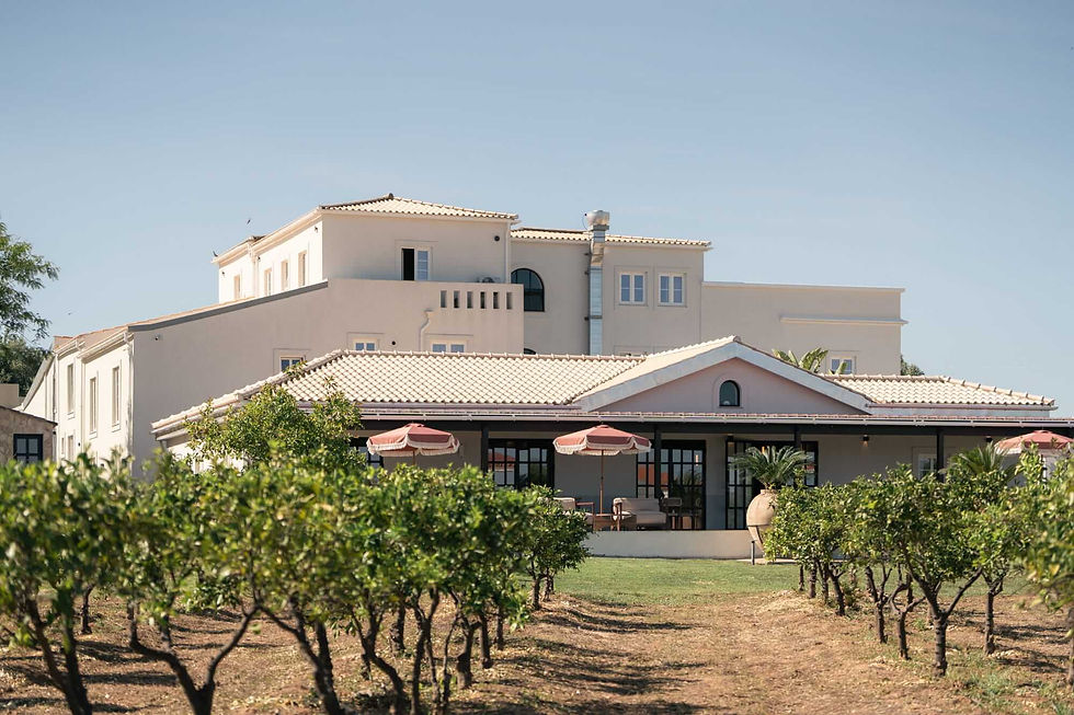 Restored 19th-century farmhouse at Shanti-Som Algarve, seen across the orange orchard